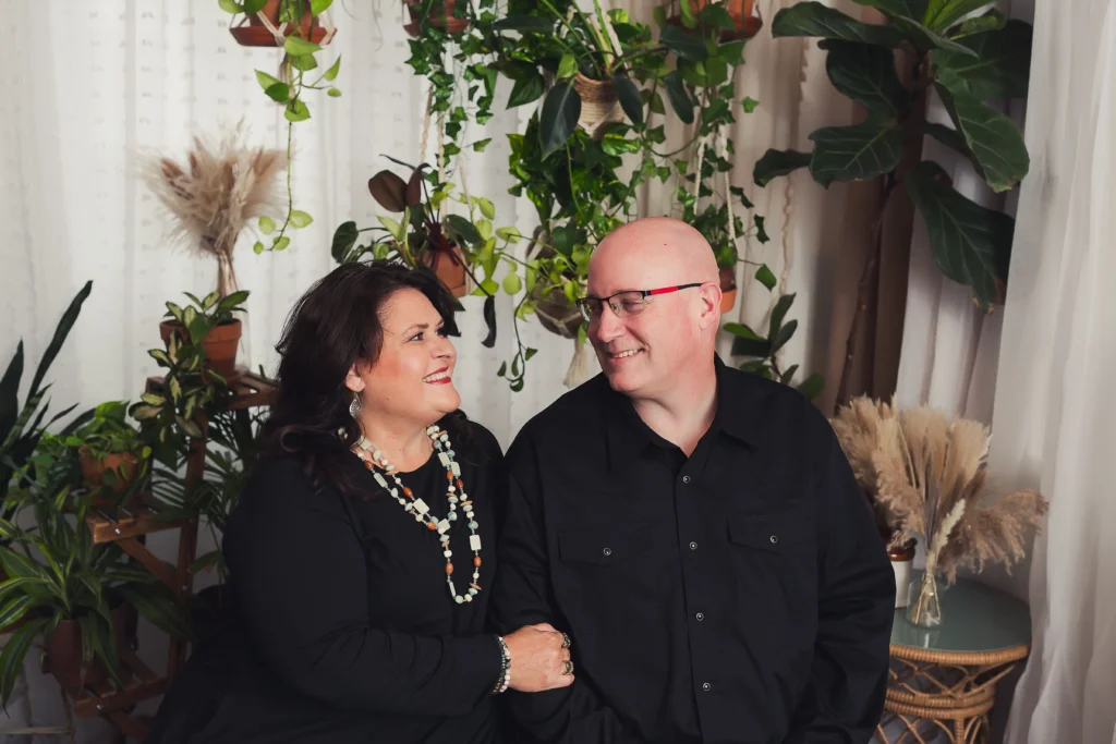 Chad Simpson, founder of RAD SEO, shares a warm moment with his wife Michele, surrounded by greenery in a cozy, inviting setting. Contact us to learn how Chad's expertise can help your contracting business thrive.